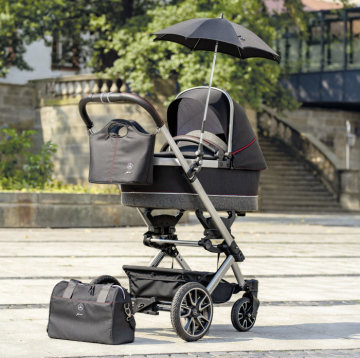 “DESSIN Sport” Infant Carrier Bed in black / a nthracite / silver with red stitching on the grip upholstery and safety belt with Undercarriage in iridium silver; Accessories: sunshade umbrella, handlebar bag and handbag.